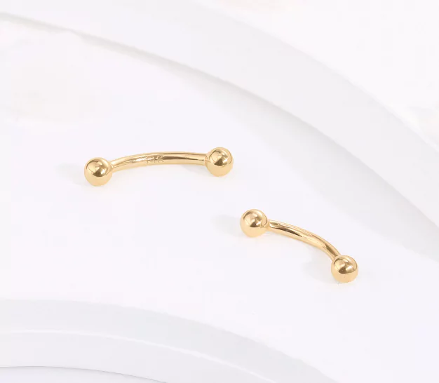 14K solid gold is a top material choice for eyebrow piercings due to its hypoallergenic properties and timeless look.