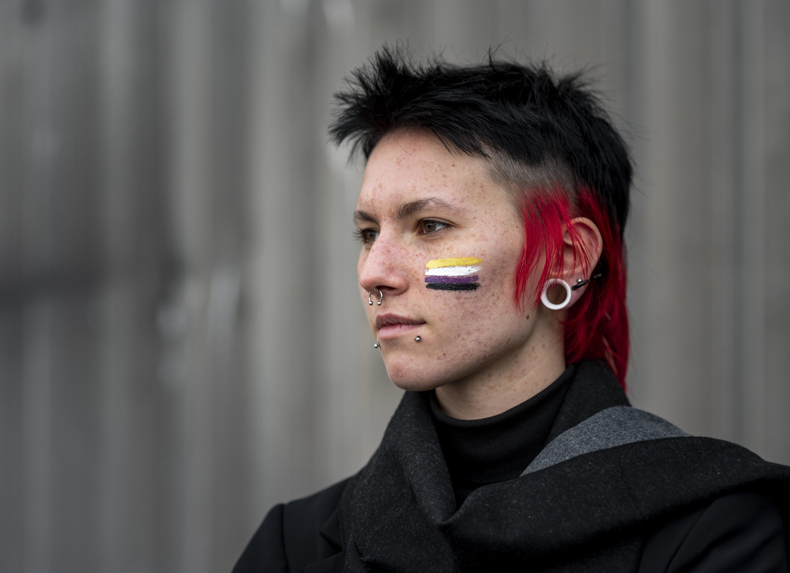 1-side-view-person-having-non-binary-flag-painted-cheek